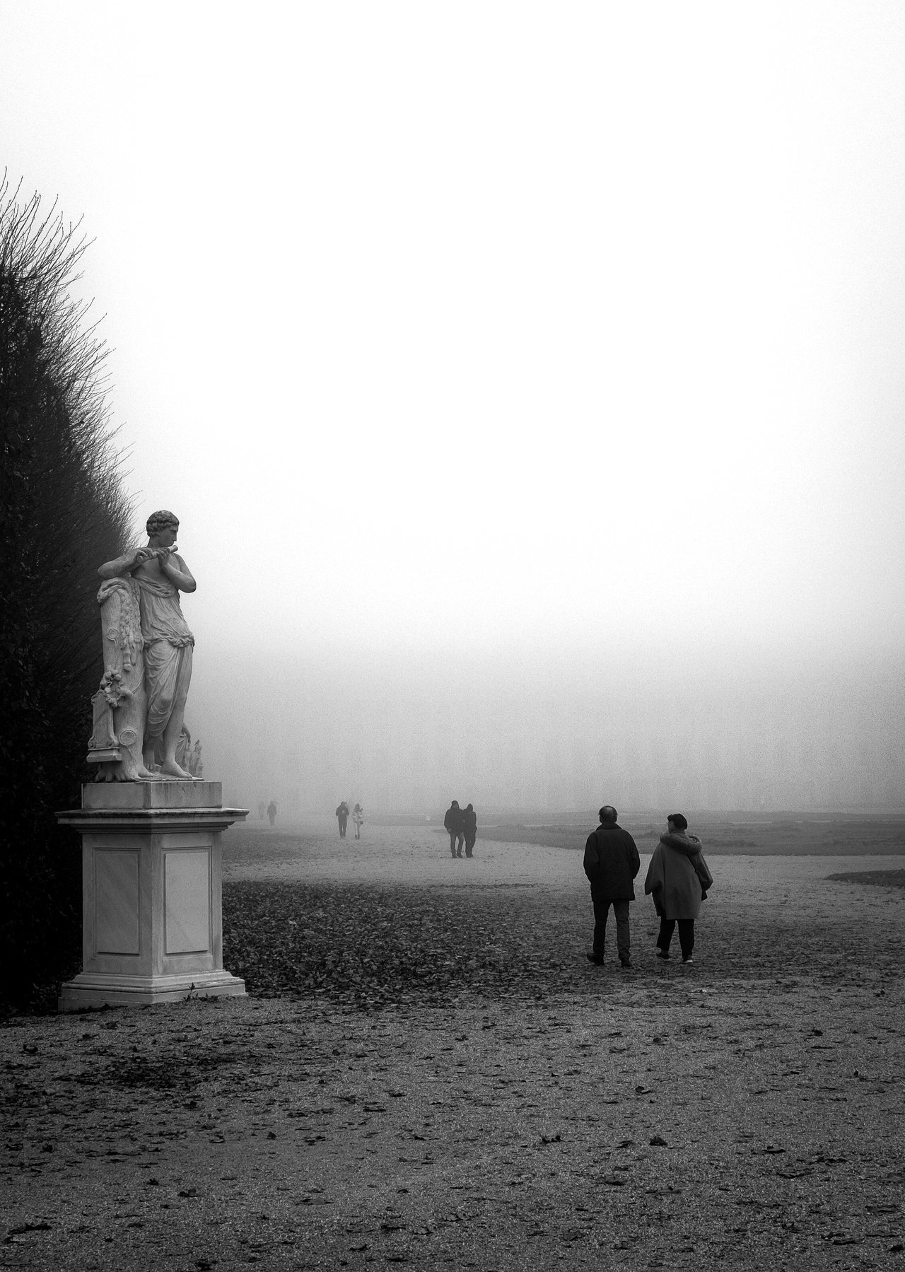 Statue und entfernte Spaziergänger im Nebel, Schlosspark Schönbrunn