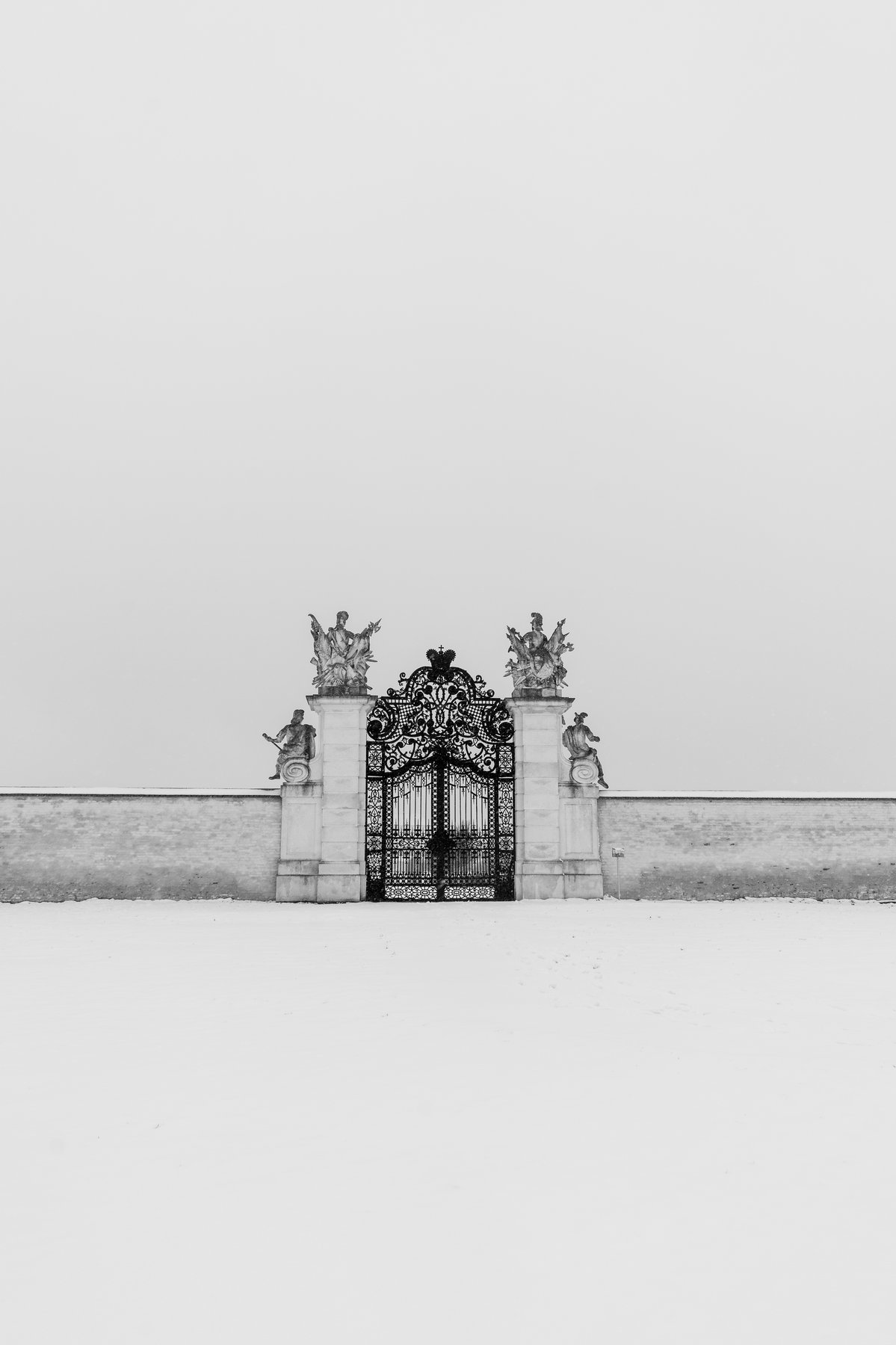 Barockes Schmiedeeisen-Tor vor weißer Schneefläche