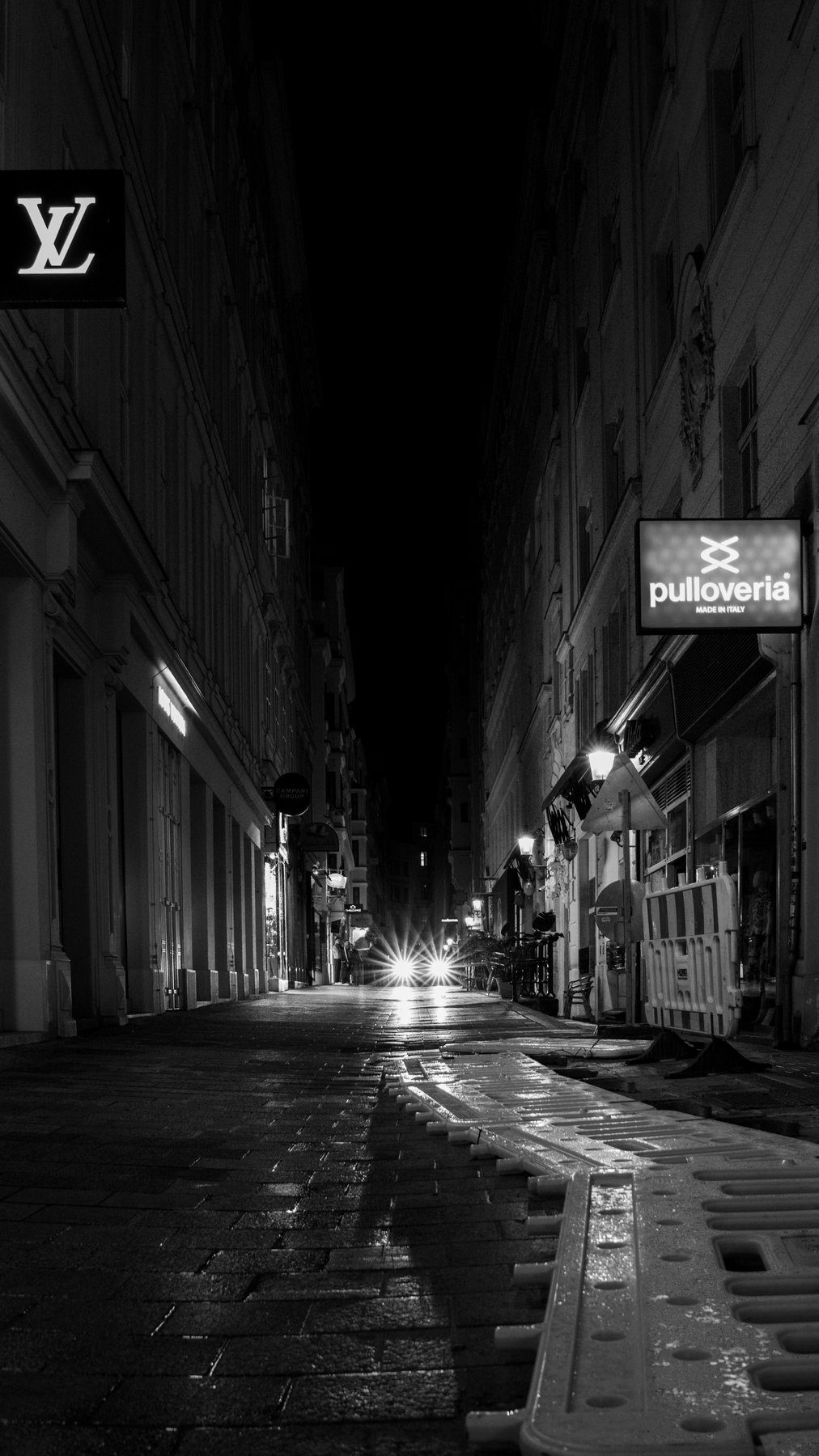 Leere nächtliche Gasse mit Louis-Vuitton-Schild und Lichtstern